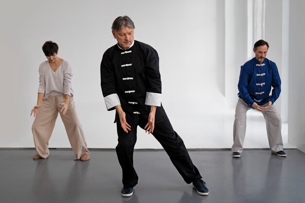 Persone di vista frontale che praticano il tai chi