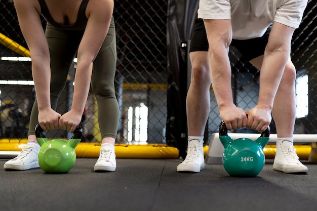 Persone di vista frontale che si allenano con i kettlebell