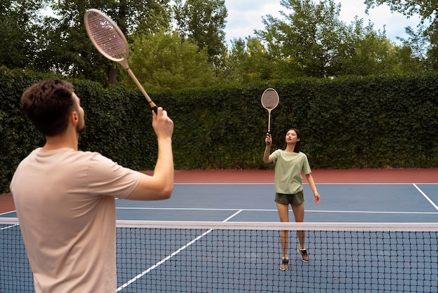 Persone di vista laterale che giocano a badminton