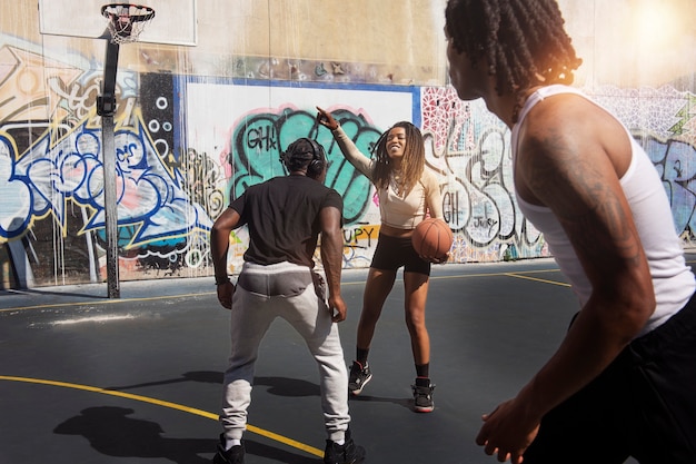 Persone di vista laterale che giocano a basket insieme