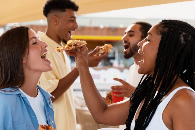 Persone di vista laterale che mangiano pizza