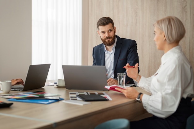 Persone di vista laterale che parlano al lavoro