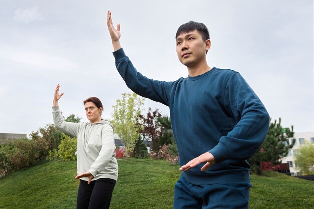 Persone di vista laterale che praticano il tai chi