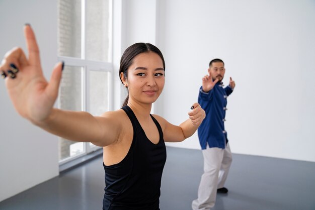 Persone di vista laterale che praticano il tai chi