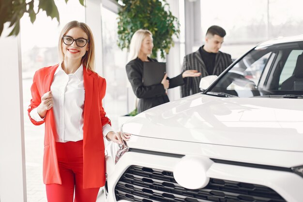 Persone eleganti e alla moda in un salone d'auto