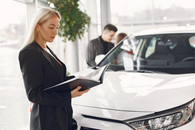 Persone eleganti e alla moda in un salone d'auto