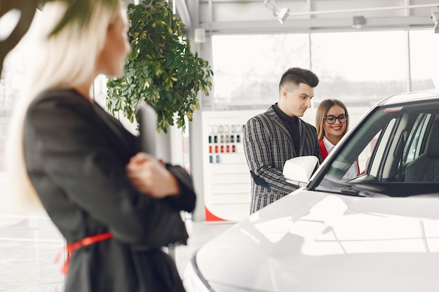 Persone eleganti e alla moda in un salone d'auto