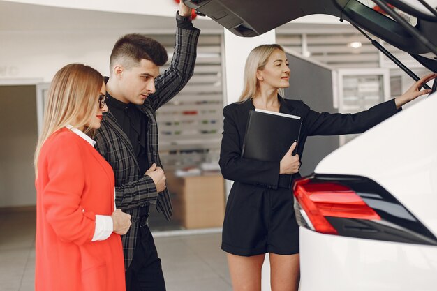 Persone eleganti e alla moda in un salone d'auto