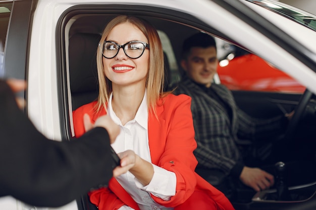 Persone eleganti e alla moda in un salone d'auto