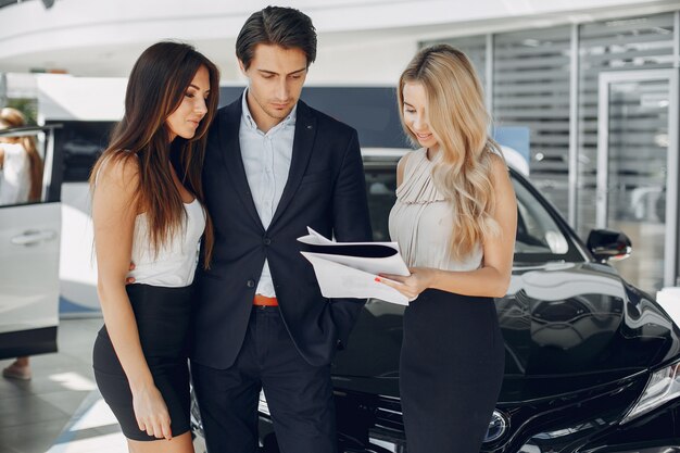 Persone eleganti e alla moda in un salone di auto