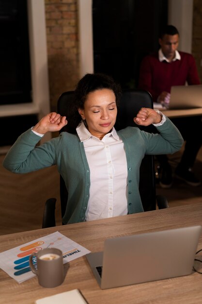 Persone esauste in ufficio che lavorano fino a tardi