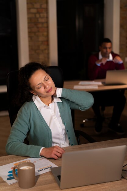 Persone esauste in ufficio che lavorano fino a tardi