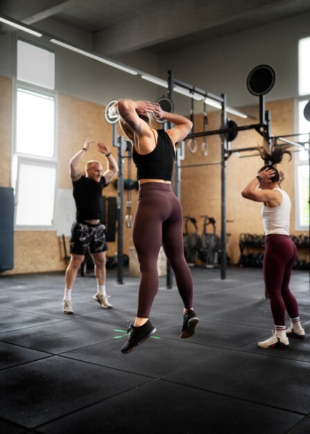 Persone in forma a tutto campo che fanno burpees insieme