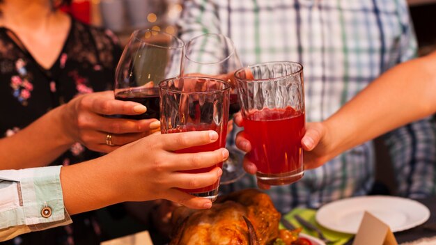 Persone in primo piano che tostano a cena