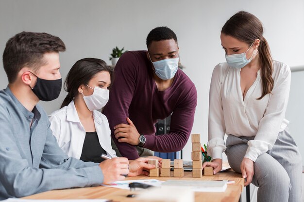 Persone in ufficio durante la pandemia che hanno una riunione insieme