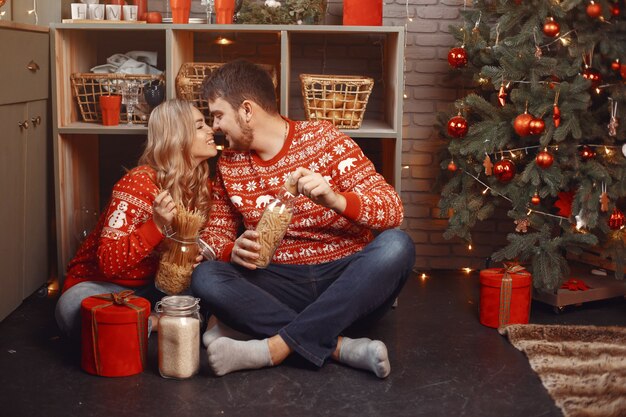 Persone in un addobbo natalizio. Uomo e donna in un maglione rosso.