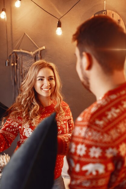 Persone in un addobbo natalizio. Uomo e donna in un maglione rosso.