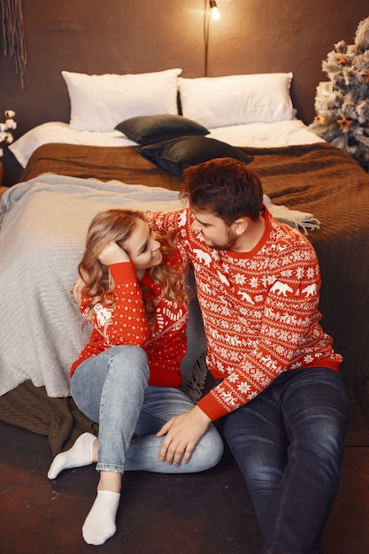 Persone in un addobbo natalizio. Uomo e donna in un maglione rosso.