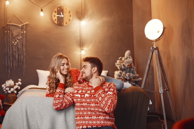 Persone in un addobbo natalizio. Uomo e donna in un maglione rosso.