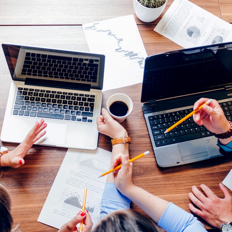 Foto gratuito persone sedute alla scrivania con laptop che lavorano