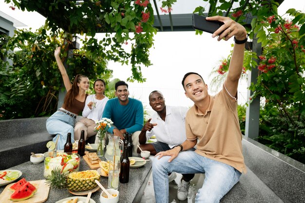 Persone sorridenti a tutto campo che si fanno selfie