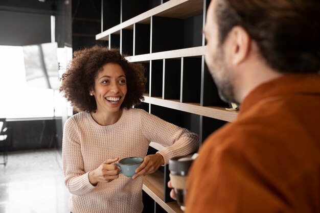 Persone sorridenti che chiacchierano al lavoro durante le pause