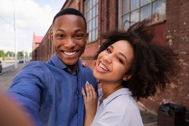 Persone sorridenti che scattano selfie a tiro medio