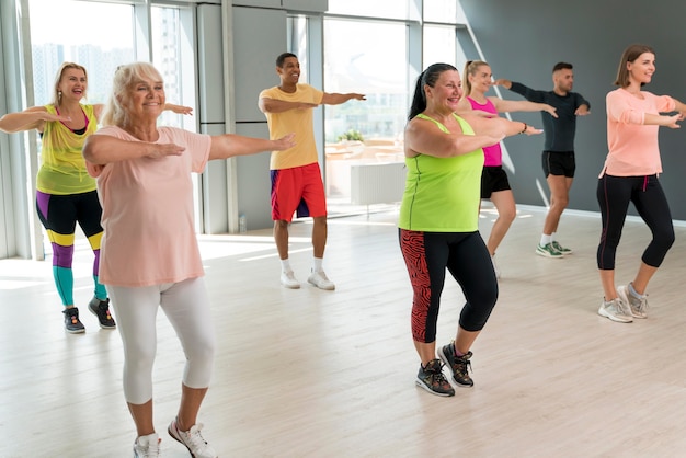 Persone sorridenti che si divertono a lezione di zumba