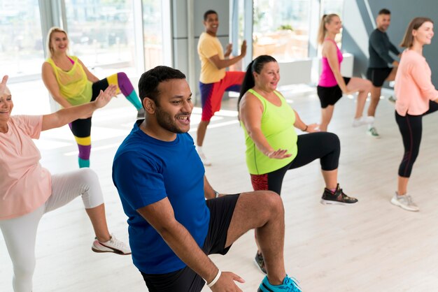 Persone sorridenti che si divertono a lezione di zumba