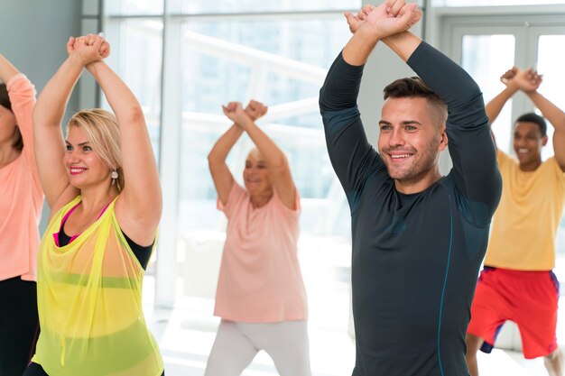 Persone sorridenti che si divertono a lezione di zumba