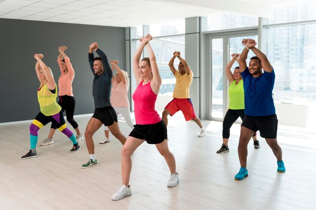 Persone sorridenti che si divertono a lezione di zumba