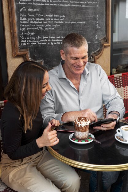 Persone sorridenti di tiro medio al bistrot