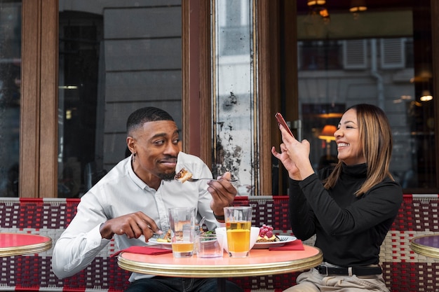 Persone sorridenti di tiro medio al bistrot