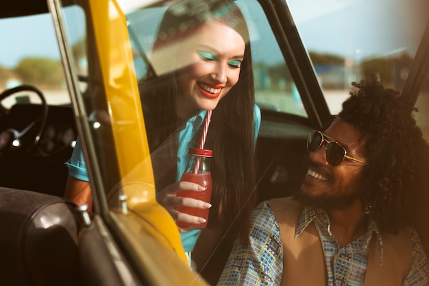 Persone sorridenti di tiro medio con auto