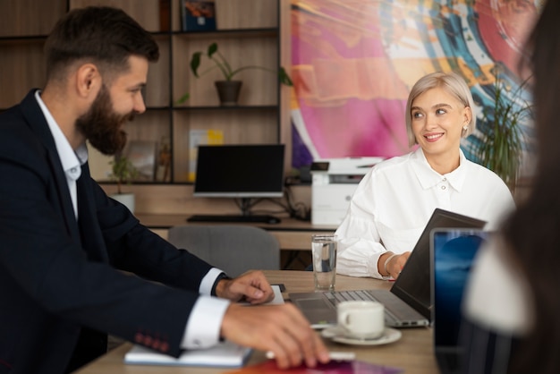 Persone sorridenti di tiro medio in ufficio