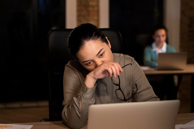 Persone stanche in ufficio che lavorano fino a tardi