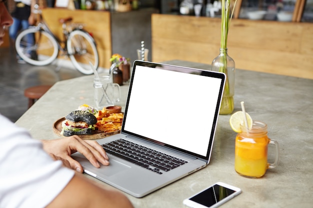 Persone, tecnologia e comunicazione. Studente caucasico utilizzando il computer portatile, mandare SMS agli amici online tramite i social media