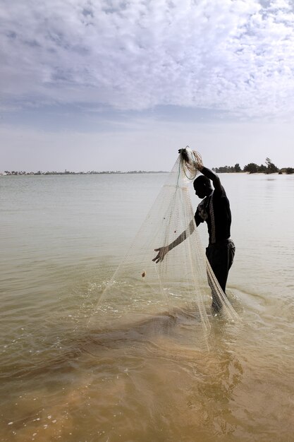 Pescatore con rete sul fiume