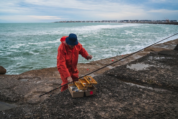 Pescatore con scatola per attrezzatura da pesca.