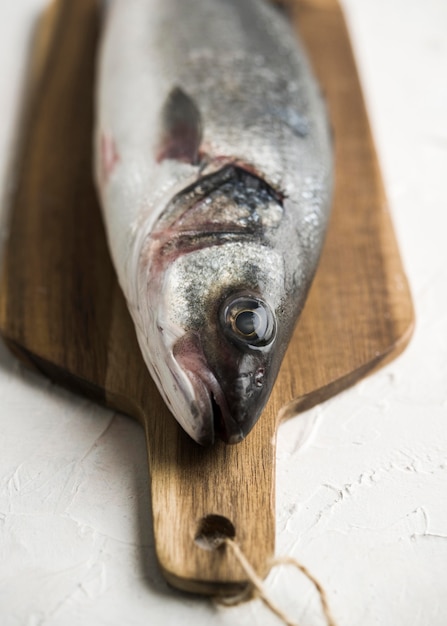 Pesce crudo di alto angolo sulla tavola di legno