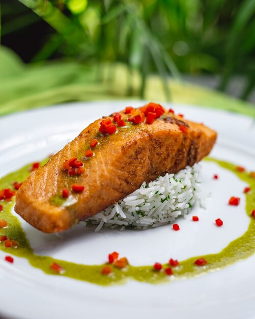 Pesce rosso fritto vista laterale con riso e salsa bolliti