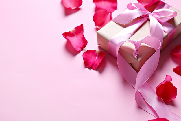Petali di rosa e confezione regalo con fiocco rosa