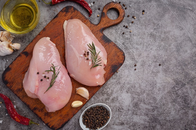 Petto di pollo crudo sulla superficie scura.