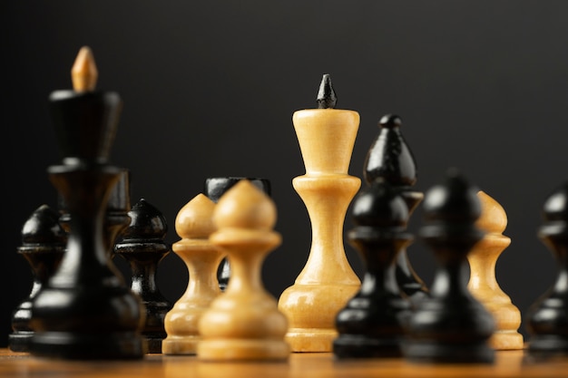 Pezzi degli scacchi in bianco e nero su sfondo nero