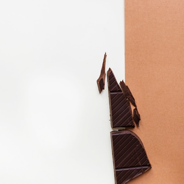 Pezzi di cioccolato fondente su sfondo bianco e marrone