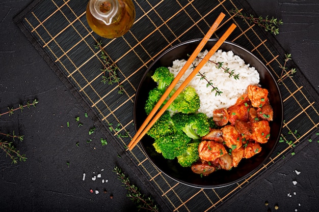 Pezzi di filetto di pollo con funghi in umido in salsa di pomodoro con broccoli e riso bolliti. Nutrizione appropriata. Uno stile di vita sano. Menu dietetico. Vista dall'alto