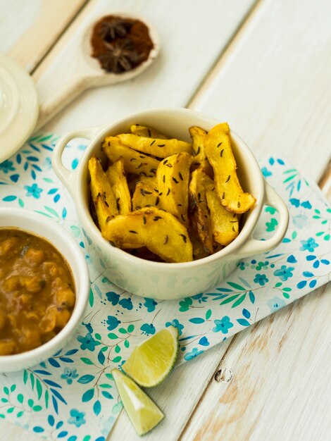 Pezzi di lime vicino a patate fritte e stufato