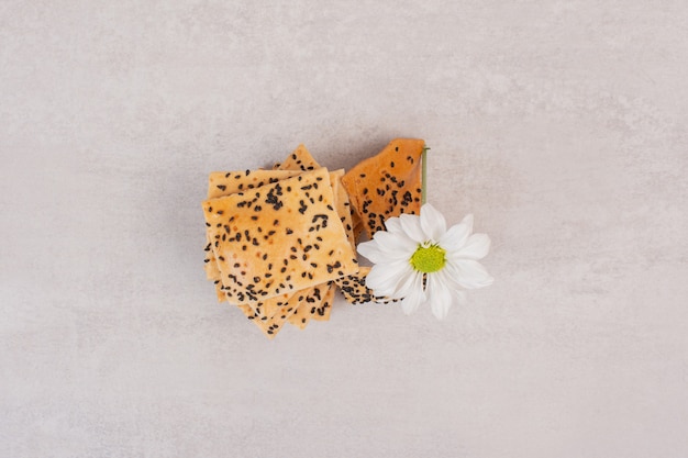 Pezzi di pane croccante con semi di sesamo nero con fiore.