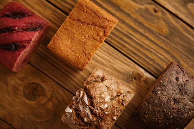 Pezzi di pane misto fatto in casa presentati in diversi livelli su un tavolo di legno come campioni per la vendita: