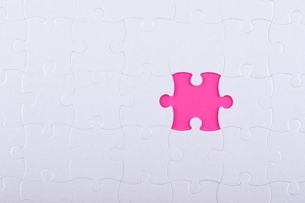 Pezzi di puzzle bianchi vista dall'alto e sfondo rosa